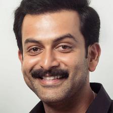 Prithviraj Sukumaran smiling with a moustache, close-up portrait