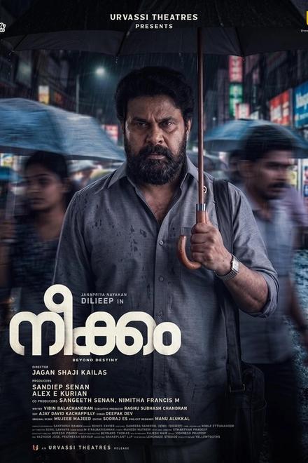 Neekkam poster with Dileep holding an umbrella on a rainy night street