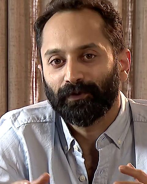 Fahadh Faasil with a beard in a grey shirt, gesturing while talking