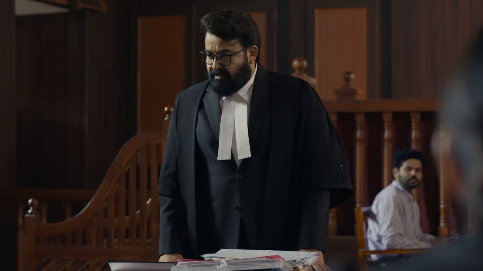 Mohanlal in a lawyer's gown and bands standing in a courtroom in the Neru trailer