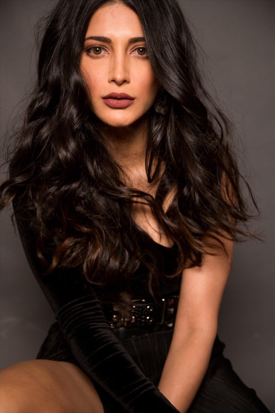 Shruti Haasan with long wavy hair in a black outfit, portrait