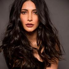 Shruti Haasan with long wavy hair in a black outfit, portrait