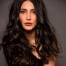 Shruti Haasan with long wavy hair in a black outfit, portrait