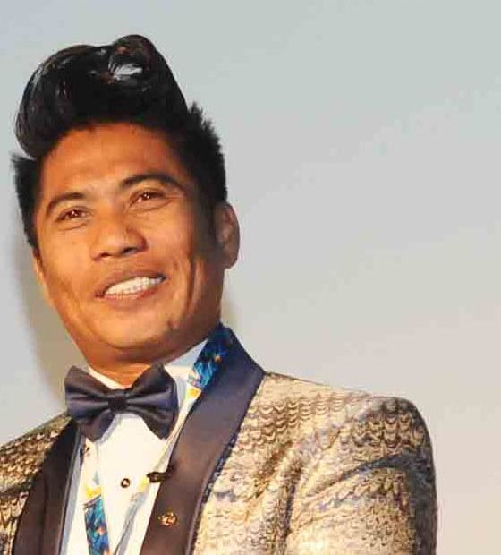 Peter Hein smiling in a gold jacket and bow tie