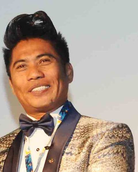 Peter Hein smiling in a gold jacket and bow tie