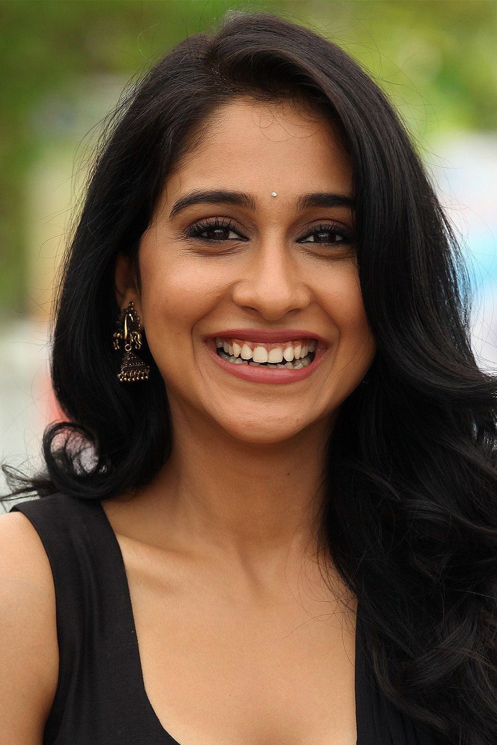 Regina Cassandra smiling with long dark hair, close-up portrait