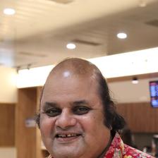 Sunil Sukhada smiling in a floral shirt, portrait