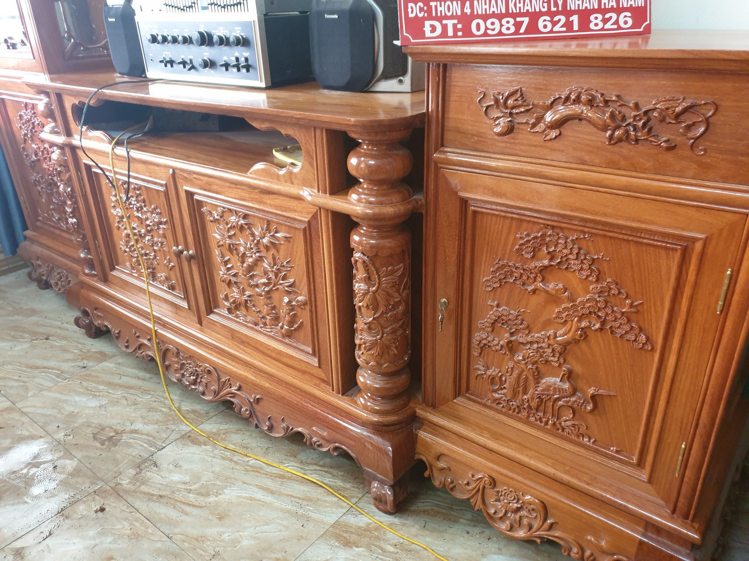 Họa tiết chạm khắc tinh xảo trên thân tủ kệ gỗ gõ đỏ.