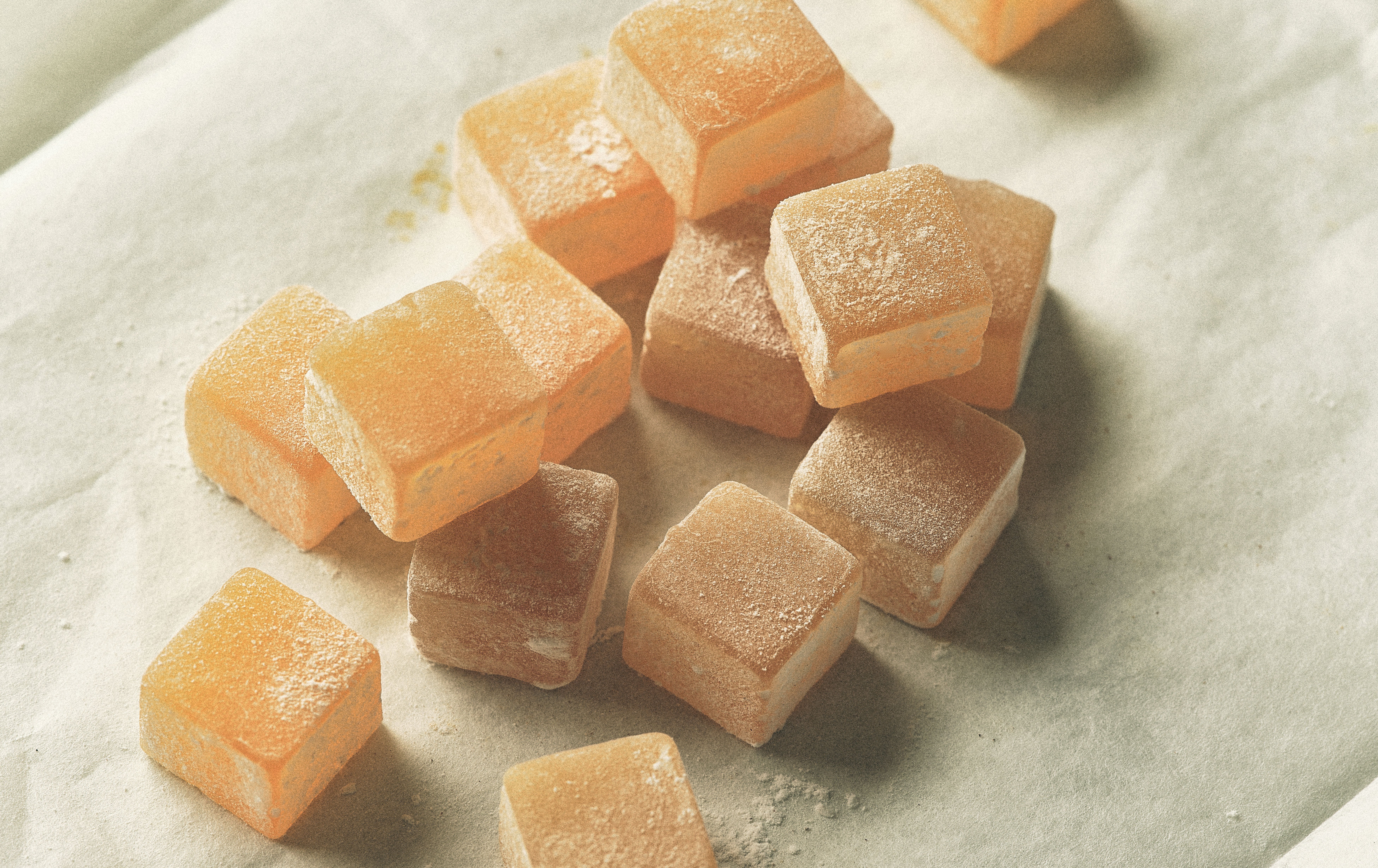 Rose Delights edible product shot of infused Turkish Delight slightly coated in powered sugar on wax paper.