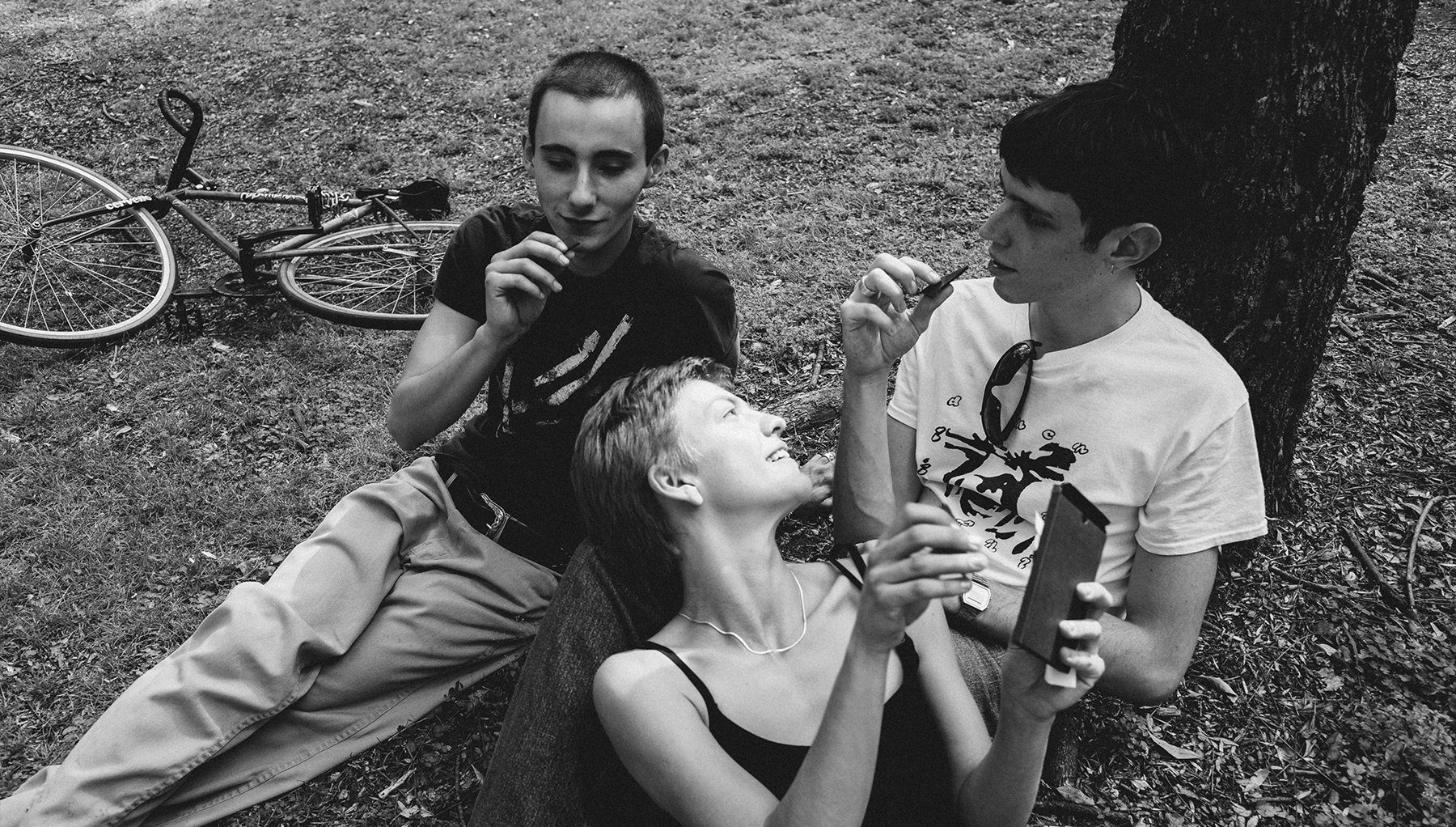 Three friends share a chocolate bar in black and white