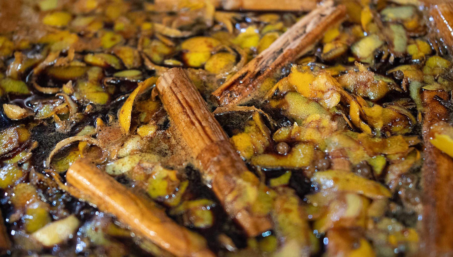house-made cola recipe steeps in cooking bot with cinnamon sticks and fruit cuttings.