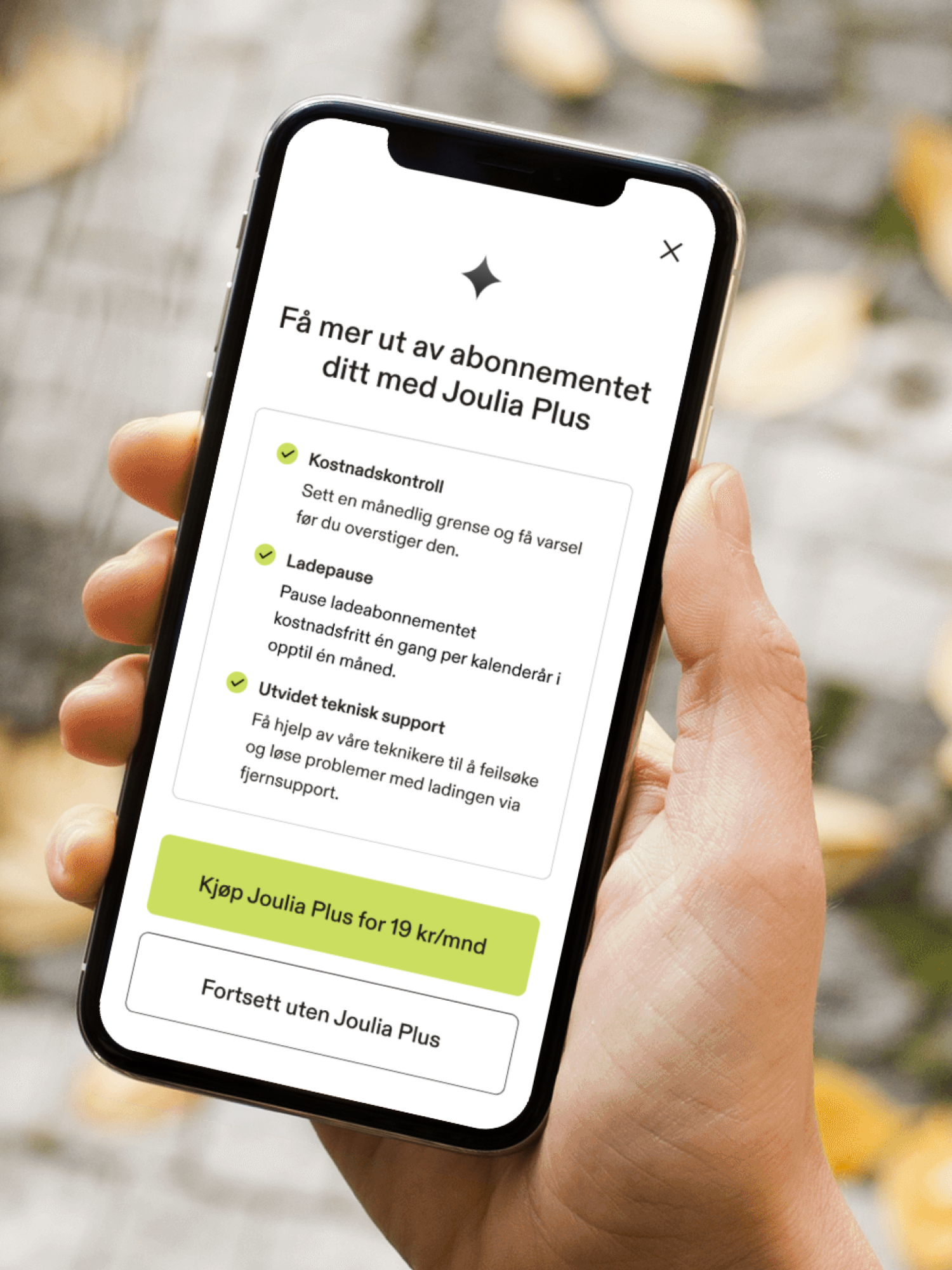 En hånd holder en smarttelefon som viser Joulia sin appskjerm med tilbud om et Joulia Plus-abonnement.