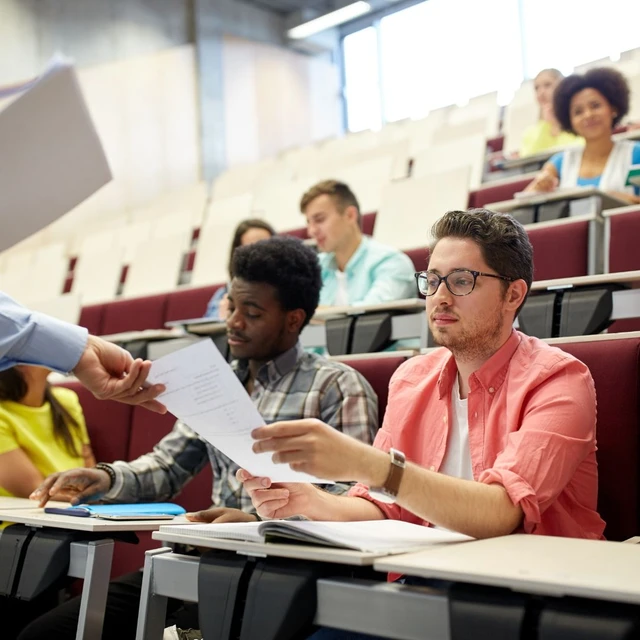 A lecturer hadning over a document to a student