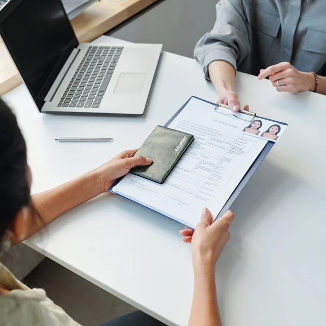 A client handing over her documents and passport to the agent