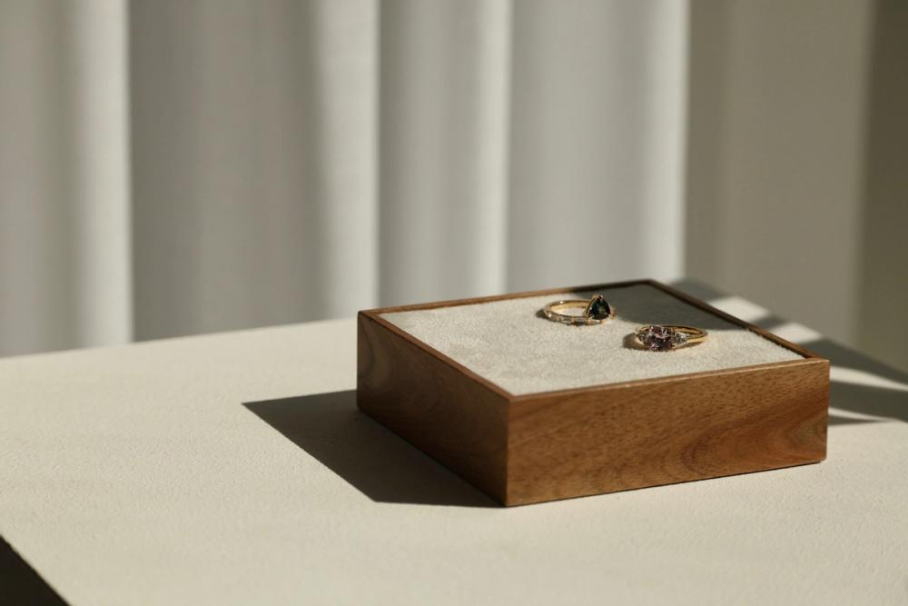 Sapphire rings laying on a wooden tray in sunlight and warm beige interior