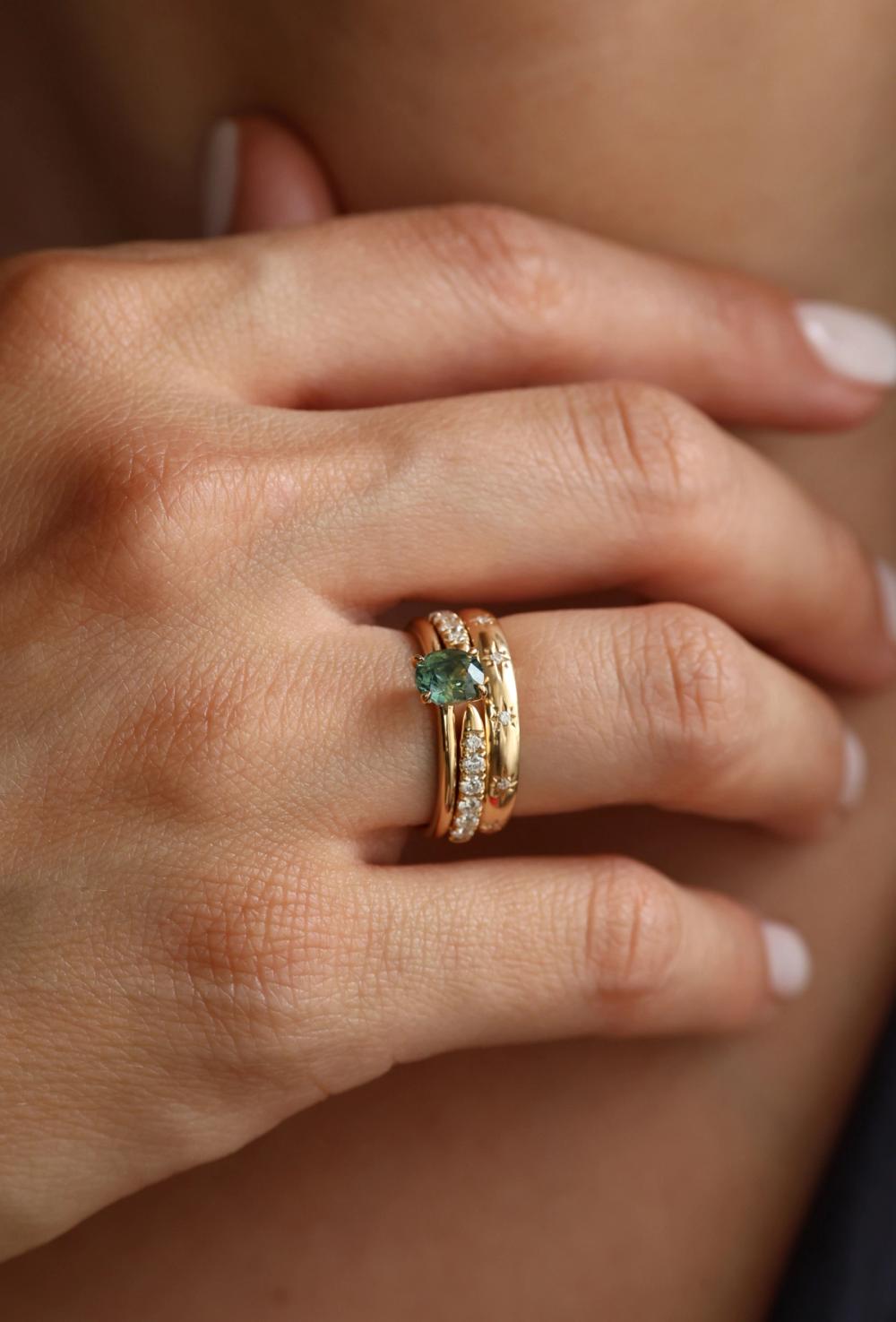 Tropical Peacock Oval Sapphire Ring, from Nangi stacked with bold Snake tail and star girl in 14 K yellow gold