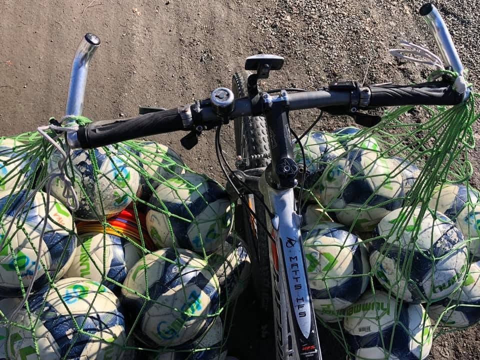 Sykkelstyre sett ovenfra, med ballnett fulle av fotballer hengende på hver side