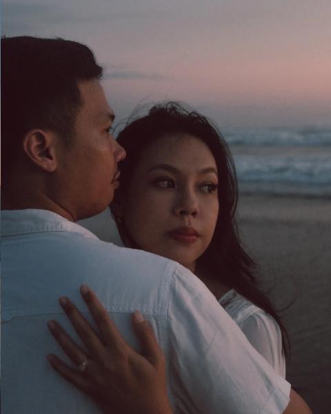 Close, quiet moment between a couple on the beach at dusk
