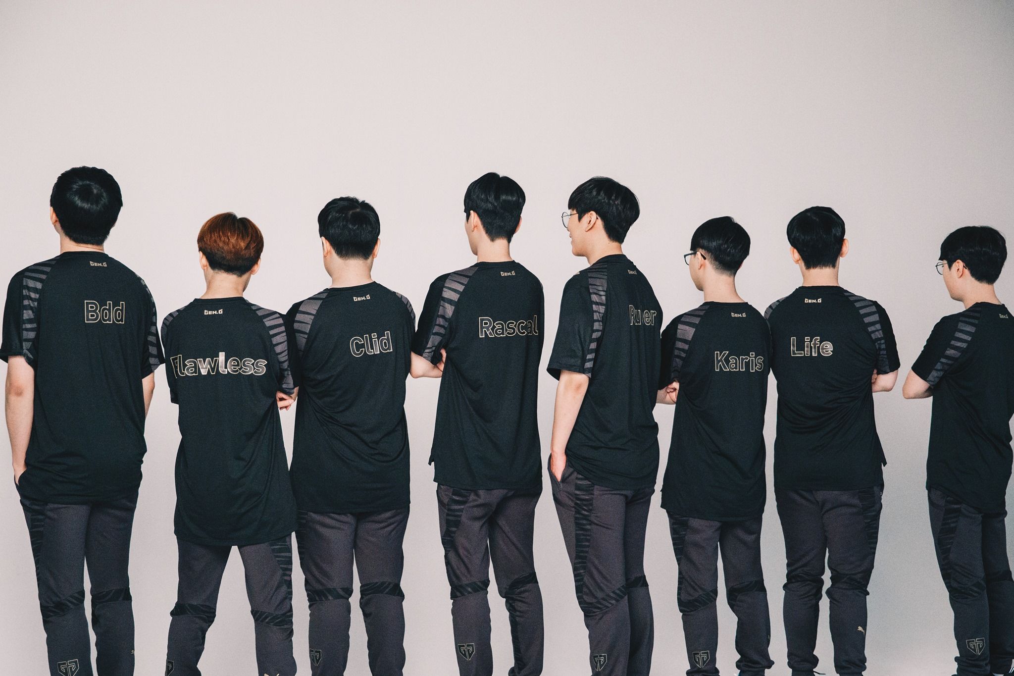 Eight men in black jerseys with player names Bdd, Flawless, Clid, Rascal, Ruler, Keria, and Life visible on their backs, facing away from the camera.