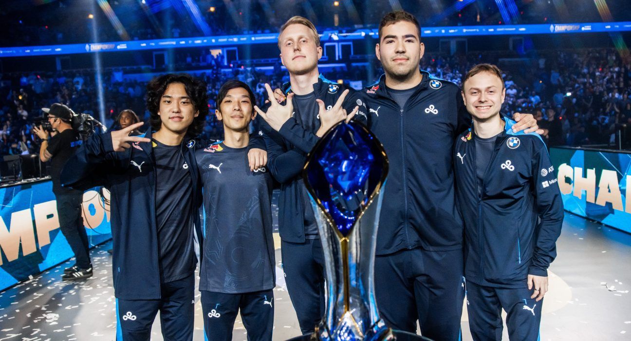 Five Cloud9 esports players celebrate with a championship trophy on stage.
