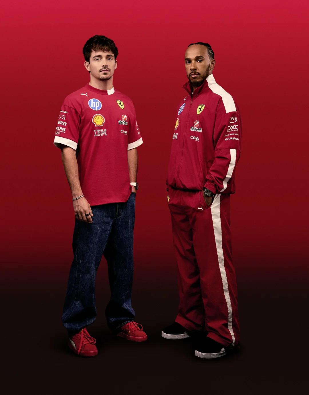 Charles Leclerc in a red Ferrari team shirt and jeans stands next to Lewis Hamilton in a red and white Ferrari tracksuit, against a red background.