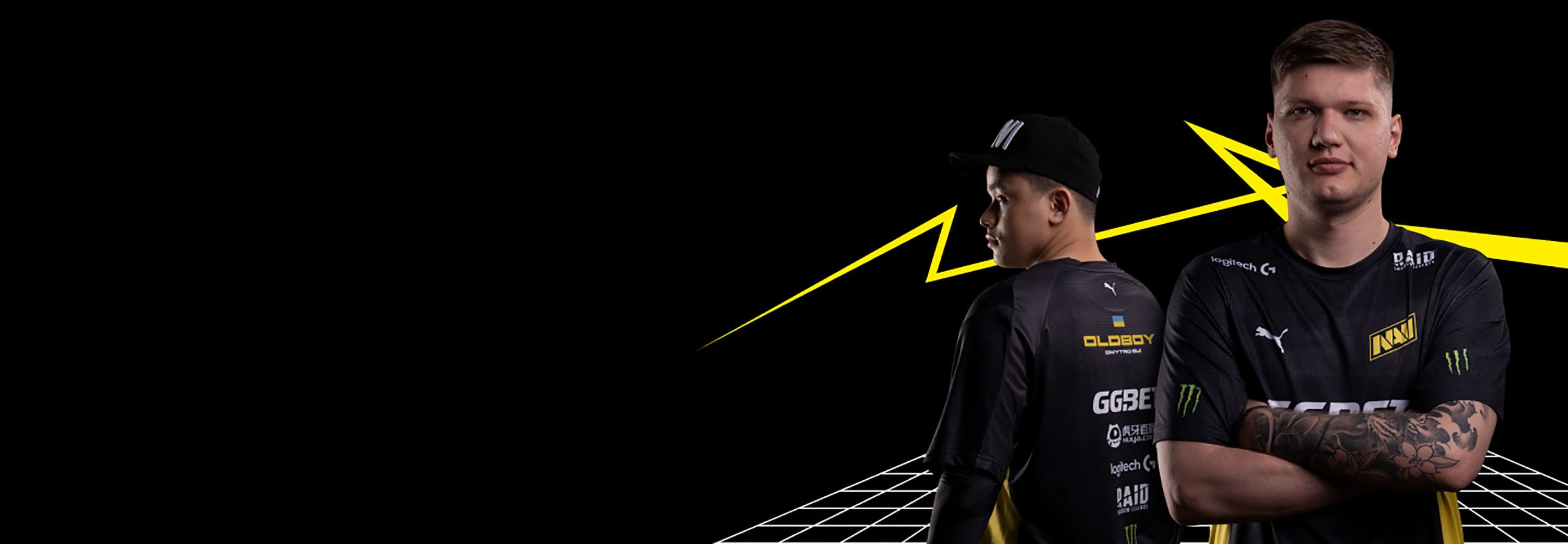 Two male esports players in black jerseys with sponsor logos, one facing forward, the other looking left, against a black background with yellow lightning bolts and a white grid.