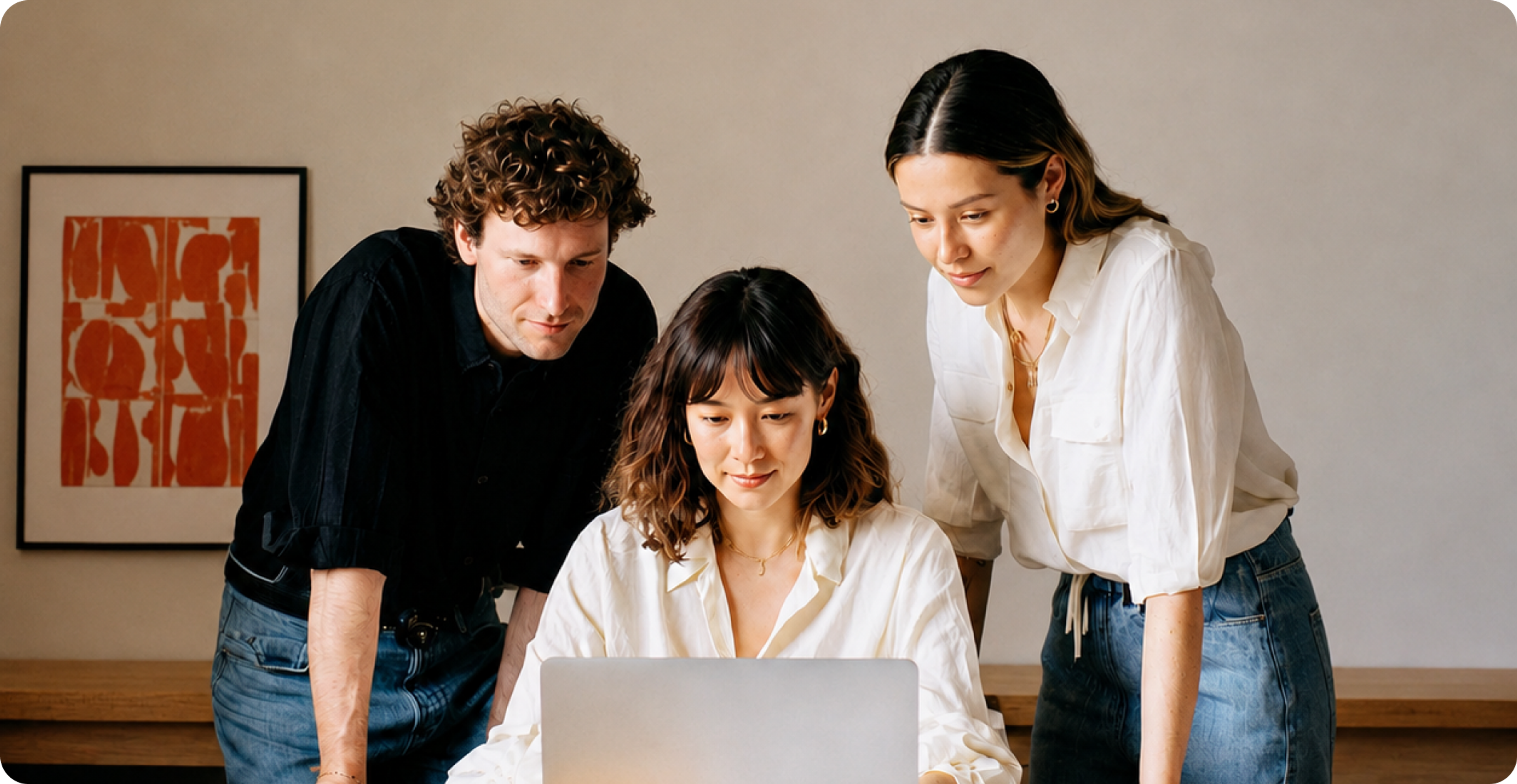 Three people looking at a laptop