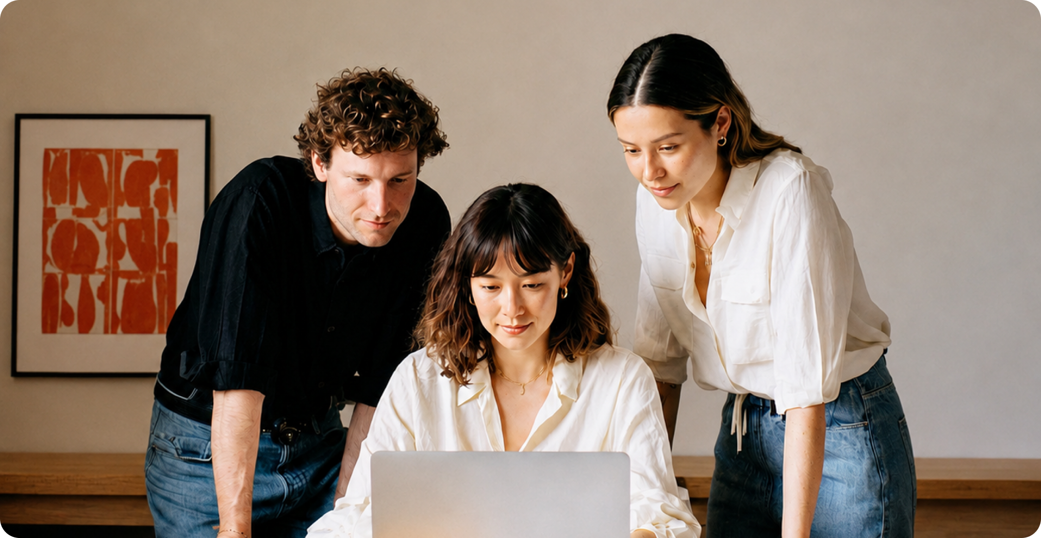 Three people looking at a laptop