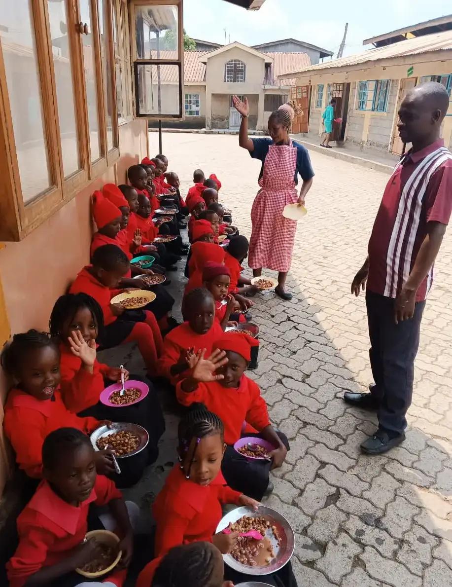 Children sharing a meal in the courtyard.