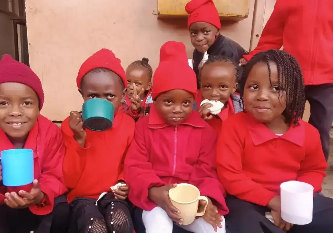 Children sharing a drink during their school break