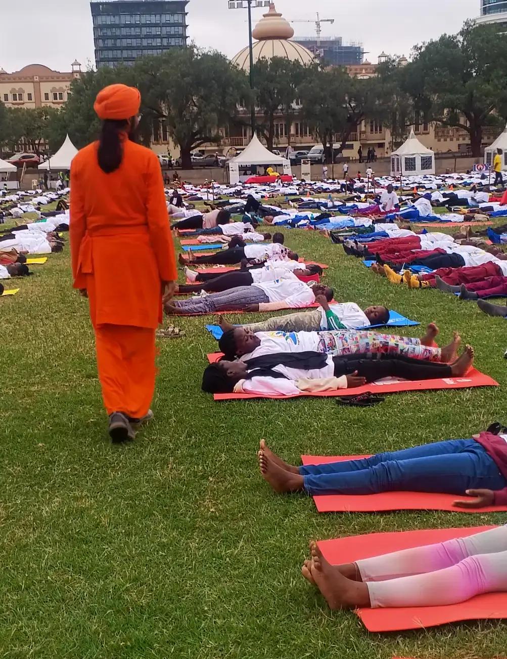 A teacher alongside participants during a relaxation session.