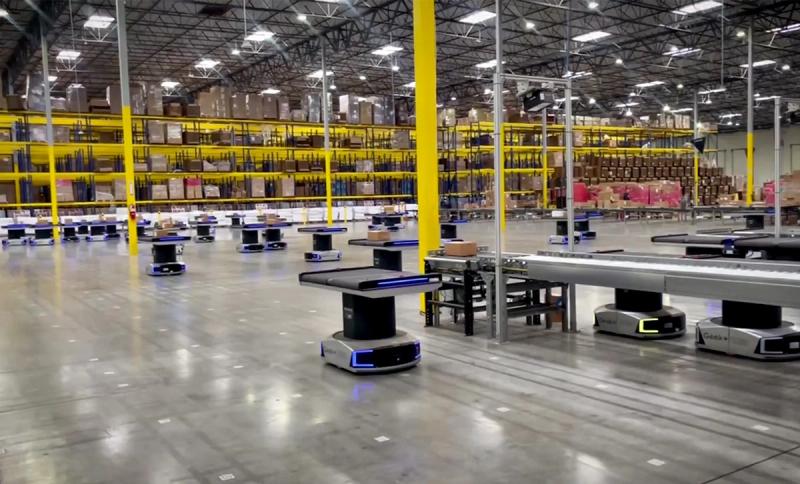 Los Angeles fulfillment center floor with autonomous mobile robots moving between conveyor sorters