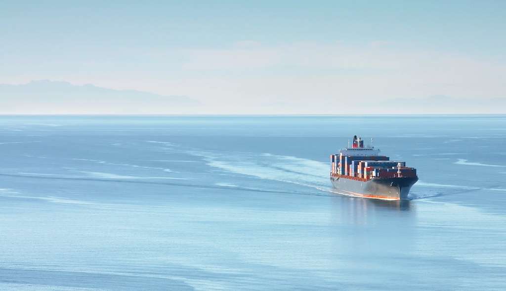 Container ship sailing across calm open water
