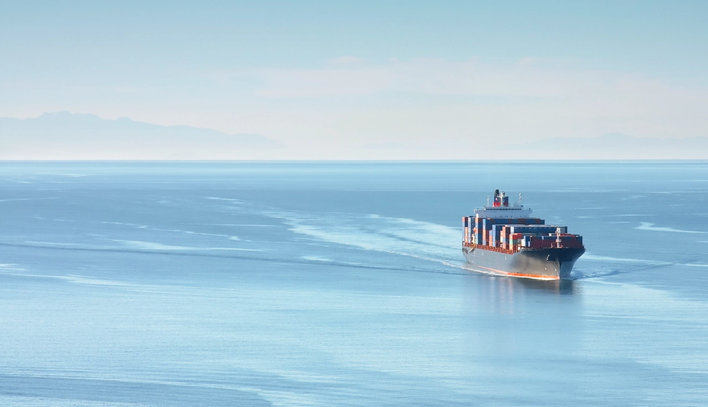 Container ship sailing across calm open water
