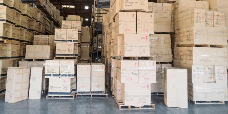 Warehouse stacked high with cardboard cartons on pallets labeled Made in China and Made in Vietnam