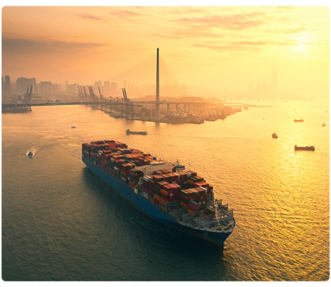 Large container ship leaving the port at sunset