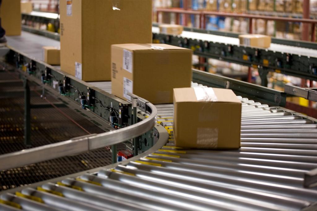 Cardboard boxes moving along a curved metal roller conveyor in a warehouse