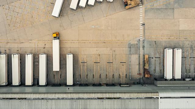 Aerial view of trucks and trailers parked at loading docks of a distribution warehouse