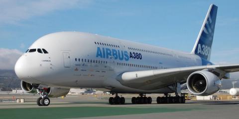 Airbus A380 superjumbo jet with branded livery parked on an airport runway