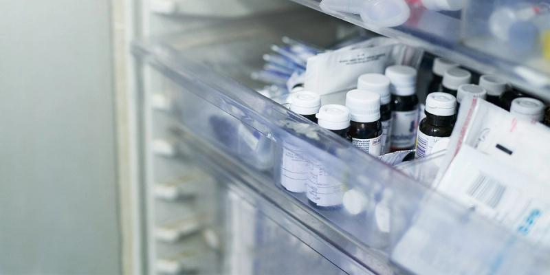 Close-up of medicine bottles and supplies stored in clear plastic pharmacy drawers