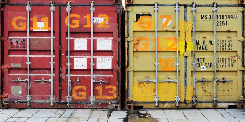 Red and yellow shipping container doors marked G11, G12, G13 and G7, with weight and capacity stencils