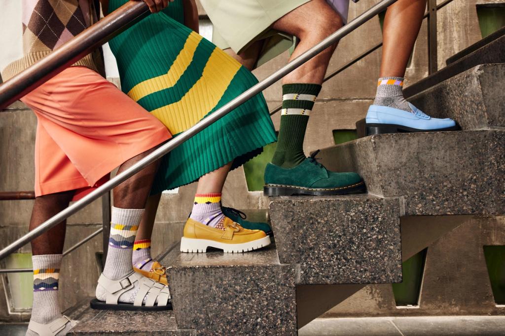 Three people in patterned Bombas socks and shoes standing on concrete steps