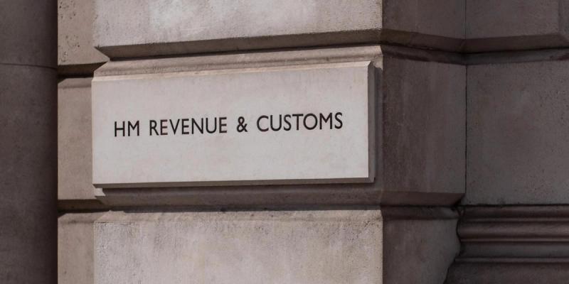 Carved stone sign reading HM Revenue & Customs on a building facade