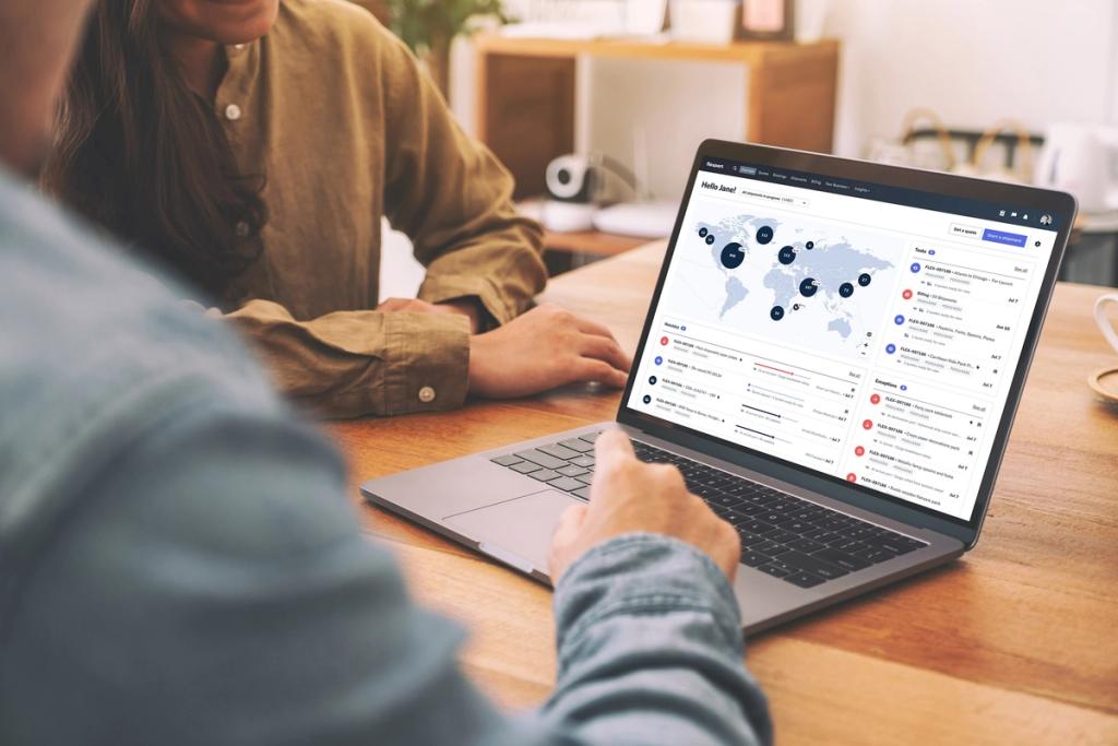 Two people at a wooden table viewing a Flexport platform dashboard with a world map on a laptop