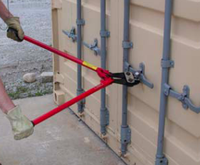Worker using long-handled bolt cutters to cut the seal lock on the doors of a shipping container