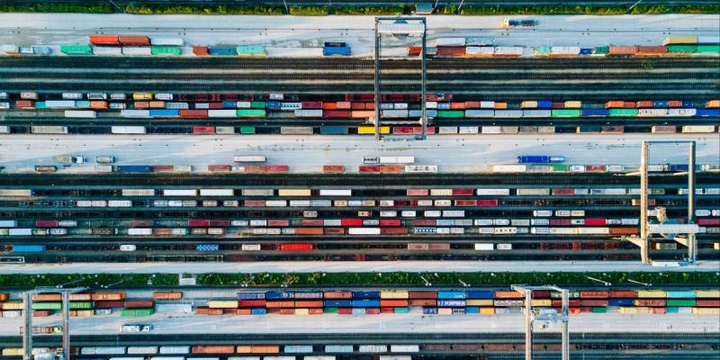 Aerial view of a rail yard packed with rows of multicolored shipping containers on freight cars