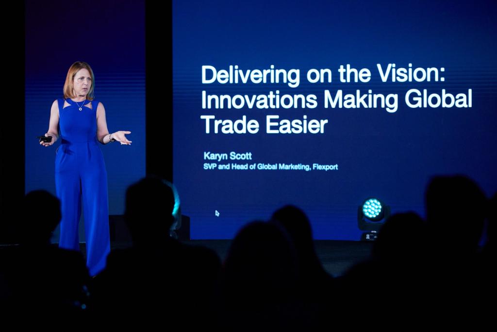 Karyn Scott, Flexport SVP and Head of Global Marketing, speaking on stage beside a slide titled Delivering on the Vision