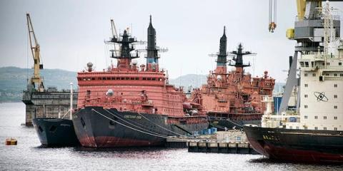 Red Soviet nuclear icebreakers moored at a port; one nearby ship bears an atom symbol
