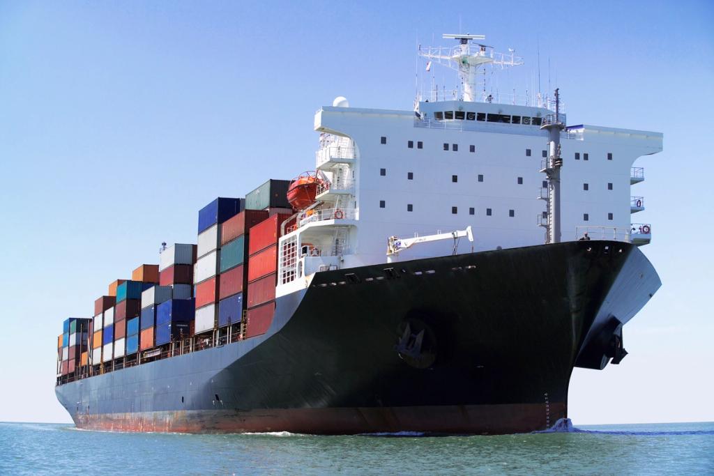 Cargo ship loaded with shipping containers cruising through open water.