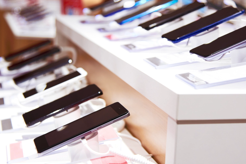 Display stand with multiple smartphones arranged in rows for customers to view and interact with in a retail setting.